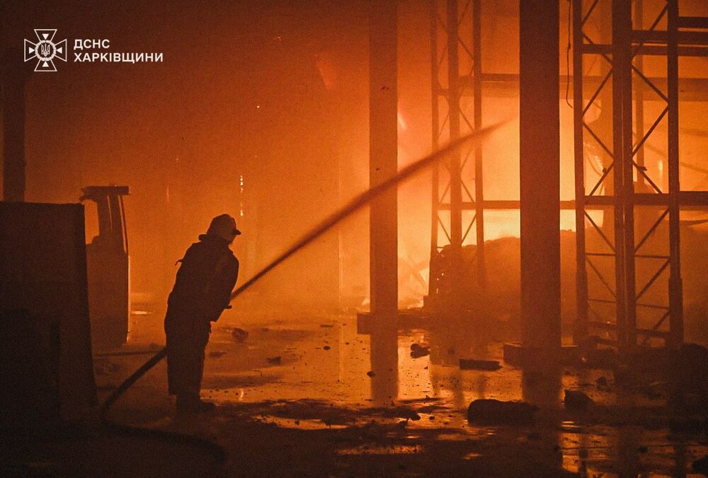 Под Харьковом не могут потушить пожар на предприятии после российского обстрела: пострадали 2 спасателя